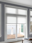 Toiles de fenêtre Light-filtering roller shades, raised halfway to showcase the scenic waterscape.
