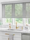 Toiles solaires Solar shades in a kitchen above the sink, providing UV protection, glare reduction, and a modern aesthetic